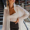 Frontal view of the Day Glow Top that features an ivory sheer chiffon material, a collar neckline, a button-up front, a long cuffed sleeve, and a flowy fit.
