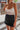 Frontal view of the I'm So Fancy Skirt that features a black colored material, a high-rise fit, a feather detailed hem, a back zipper closure, and a mini length.