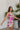 Frontal view of the Meet Me At The Disco Dress that features a multi-colored print, a V neckline, a sleeveless design with thin adjustable straps, a back zipper closure, and a mini length.