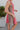 Side view of the All Caught Up Dress that features a multi-colored denim material, a square neckline, a sleeveless design with thick straps, a color block design, and a side zipper closure.