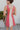 Back view of the All Caught Up Dress that features a multi-colored denim material, a square neckline, a sleeveless design with thick straps, a color block design, and a side zipper closure.