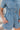 Frontal View of the Heading South Romper that features a blue colored material, a collar neckline, a short cuffed sleeve, a button-up front, two front pockets at the chest, a cinched waist, two side pockets, cuffed bottom hem, and two back pockets.