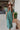 Frontal view of the Places To Be Midi Dress that features a soft tshirt material, a rounded neckline, a short sleeve, a midi length, side slits, a rounded hemline, and a flowy fit.
