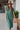 Frontal view of the Places To Be Midi Dress that features a soft tshirt material, a rounded neckline, a short sleeve, a midi length, side slits, a rounded hemline, and a flowy fit.