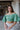 Frontal view of the In The Air Top that features a green colored metallic material, a V neckline, a half puffy sleeve, a ruched front, a smocked back, and a cropped fit.