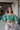 Frontal view of the In The Air Top that features a green colored metallic material, a V neckline, a half puffy sleeve, a ruched front, a smocked back, and a cropped fit.