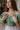Frontal view of the In The Air Top that features a green colored metallic material, a V neckline, a half puffy sleeve, a ruched front, a smocked back, and a cropped fit.