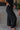 Side view of the Keep Cool Pants that features a black terry cloth material, a high-rise fit, a thick elastic band waist, and a wide leg fit.