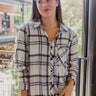 Frontal view of the Remember Me top that features a navy and blue plaid, a collar neck, a button-up front, a front pocket, and a long cuffed sleeve.