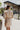 Back view of the Means Business Dress that features a cream colored chiffon material, a surplice lapel neckline, a long sleeve, a wrap front with a tie, and a mini length.
