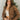 Front view of model wearing the Next Adventure Puffer Jacket in Brown that has a brown nylon material, a puffer design, a long sleeve, a zip-up front, and front pockets. 