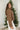 Side view of model wearing the Next Adventure Puffer Jacket in Brown that has a brown nylon material, a puffer design, a long sleeve, a zip-up front, and front pockets. 