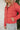 Close side view of model wearing the Next Adventure Puffer Jacket in Hibiscus that has a dark pink nylon material, a puffer design, a long sleeve, a zip-up front, and front pockets. 
