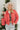 Front view of model wearing the Next Adventure Puffer Jacket in Hibiscus that has a dark pink nylon material, a puffer design, a long sleeve, a zip-up front, and front pockets. Model is holding packable pouch.