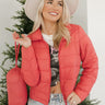 Front view of model wearing the Next Adventure Puffer Jacket in Hibiscus that has a dark pink nylon material, a puffer design, a long sleeve, a zip-up front, and front pockets. Model is holding packable pouch.