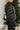 Side view of model wearing the Next Adventure Puffer Jacket in Black that has a black nylon material, a puffer design, a long sleeve, a zip-up front, and front pockets. 