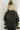 Back view of model wearing the Next Adventure Puffer Jacket in Black that has a black nylon material, a puffer design, a long sleeve, a zip-up front, and front pockets. 