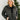 Front view of model wearing the Next Adventure Puffer Jacket in Black that has a black nylon material, a puffer design, a long sleeve, a zip-up front, and front pockets. 