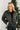 Front view of model wearing the Next Adventure Puffer Jacket in Black that has a black nylon material, a puffer design, a long sleeve, a zip-up front, and front pockets. 