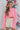 Front view of model wearing the All I Want Sweater, that has pink knit fabric with thick ribbed trim, a high round neck, and drop-shoulder long sleeves with folded cuffs. Sweater is tucked up.