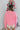 Back view of model wearing the All I Want Sweater, which features pink knit fabric with thick ribbed trim, a high round neck, and drop-shoulder long sleeves with folded cuffs