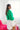 Side view of model wearing the Make A Statement Sweater in Green that has green knit fabric, a cropped waist, a round neckline, and long balloon sleeves