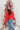 Front view of model wearing the he Holiday Spirit Mock Neck Sweater that has red fabric with open knit details, a mock neckline, dropped shoulders, long sleeves, and ribbed trim.