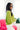 Side view of model wearing the Go Boldly Chenille Sweater in Green that has lime green chenille fabric, a v-neck and back, and long batwing sleeves