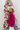Side view of model wearing the Favorite Time Of Year Sweater which features dark fuchsia knit fabric, a v-neckline, ribbed trim detailing, and long balloon sleeves.