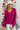 Close up view of model wearing the Favorite Time Of Year Sweater which features dark fuchsia knit fabric, a v-neckline, ribbed trim detailing, and long balloon sleeves.
