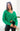 Front view of model wearing the Merry And Bright Sweater that has green knit fabric, a cropped waist, a ruched drawstring front, a v neckline, and long balloon sleeves.