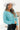 Front view of model wearing the Go Boldly Chenille Sweater in Blue that has blue chenille fabric, a cropped waist, a v-neckline, and long batwing sleeves