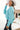 Side view of model wearing the Go Boldly Chenille Sweater in Blue that has blue chenille fabric, a cropped waist, a v-neckline, and long batwing sleeves