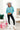 Full body ront view of model wearing the Go Boldly Chenille Sweater in Blue that has blue chenille fabric, a cropped waist, a v-neckline, and long batwing sleeves