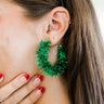 Side view of model wearing the You Give Me Joy Earrings in Green is an open hoop style earring, featuring green textured frills.