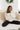 Front view of model wearing the Warm And Fuzzy Pullover in Ivory that has soft fleece fabric, long raglan sleeves, ribbed trim, and a round neckline