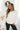Front view of model wearing the Warm And Fuzzy Pullover in Ivory that has soft fleece fabric, long raglan sleeves, ribbed trim, and a round neckline