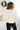 Back view of model wearing the Warm And Fuzzy Pullover in Ivory that has soft fleece fabric, long raglan sleeves, ribbed trim, and a round neckline