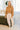 Full body front view of model wearing the No Plans Pullover in Brown that has light brown waffle-knit fabric, long batwing sleeves, a hood with an ivory drawstring, and a wide fit