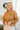 Front view of model wearing the No Plans Pullover in Brown that has light brown waffle-knit fabric, long batwing sleeves, a hood with an ivory drawstring, and a wide fit