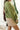 Side view of model wearing the Warm And Fuzzy Pullover in Olive that has soft fleece fabric, long raglan sleeves, ribbed trim, and a round neckline.