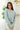 Front view of model wearing the No Plans Pullover Hoodie  in Blue that has waffle-knit fabric, long batwing sleeves, a hood with an ivory drawstring, and a wide fit