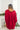 Back view of model wearing the Bristol Oversized Satin Top in Red that has red satin fabric, a button-up front with a collared neckline, one chest pocket, long sleeves with buttoned cuffs, and an oversized fit