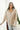 Front view of model wearing the Checkmate Satin Top that has taupe satin fabric with a monochromatic checker print, a button-up front with a collar, and long sleeves with buttoned cuffs.