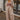 Full body front view of model wearing the Keep It Classic Pants that have khaki colored fabric, two front pockets, a front zipper and hook closure, belt loops, and wide legs with pleated details.