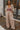 Full body front view of model wearing the Keep It Classic Pants that have khaki colored fabric, two front pockets, a front zipper and hook closure, belt loops, and wide legs with pleated details.
