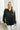Front view of the Fancy Me Satin Top in Black which features black satin fabric, a button-up front with a collared neckline, one chest pocket, and long raglan sleeves with buttoned cuffs.