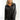 Front view of model wearing the Bristol Oversized Satin Top in Black that has black satin fabric, a button-up front with a collar, one pocket and long sleeves. 
