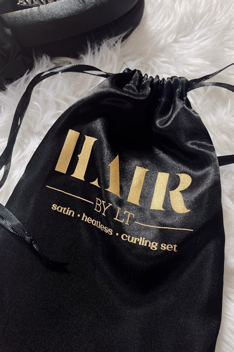 Image shows the Satin Curless Hair Set black satin bag which reads "Hair By LT. Satin Heatless Curling set." in gold. 