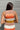 Back view of the Day Dreamer Tank Top that features a stretchy knit material, a multicolored thick stripe pattern, a rounded neck, ribbed hems, a sleeveless design with thick straps, and a cropped fit.